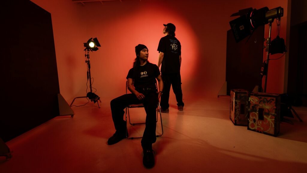 Dynamic studio session featuring two men in vibrant lighting. Artistic portrayal with creative setup.